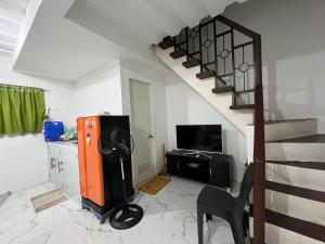 Affordable 2 storey transient house with free wifi in Camella Homes Koronadal的客厅设有楼梯、电视和椅子