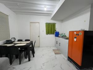 Affordable 2 storey transient house with free wifi in Camella Homes Koronadal的厨房以及带桌子和冰箱的用餐室