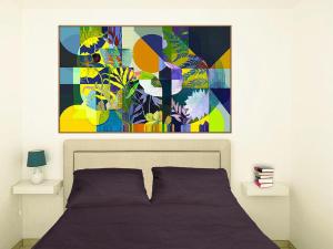 圣凯撒利亚温泉19 Summer Suites的卧室配有一张床,墙上挂有绘画作品