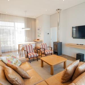 布鲁堡史特兰Bokkombaai的客厅配有沙发、椅子和电视