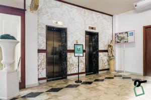 切法卢HOTIDAY Hotel Cefalù的大堂设有两扇门,并在瓷砖地板上标有标志