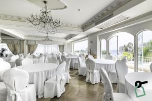 切法卢HOTIDAY Hotel Cefalù的一间设有白色桌椅和吊灯的客房
