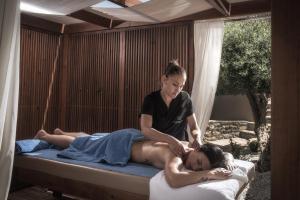伊罗达Elounda Infinity Exclusive Resort & Spa - Adults Only的女人在床上给女人按摩