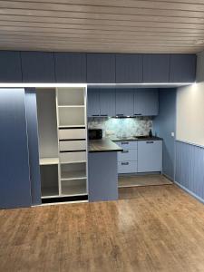 派尔努温特劳本公寓的一间空厨房,里面装有蓝色的橱柜和柜台