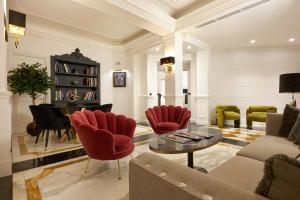 罗马巴贝里尼酒店的客厅配有红色椅子和钢琴