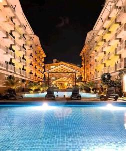 麦克坦119 Amani Grand Mactan Resort的一座游泳池,在晚上在建筑物前