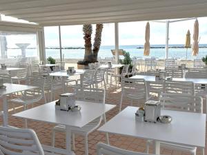 圣巴特罗摩艾美尔黛勒洛斯酒店的一间设有白色桌椅的海洋餐厅