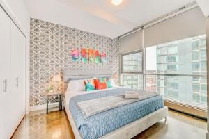 卡尔加里Luxury 2BR Condo - King Bed - Stunning City Views的一间卧室设有一张床和一个大窗户