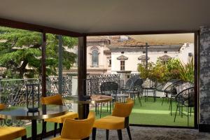 罗马巴贝里尼酒店的阳台配有桌椅,享有建筑的景致。