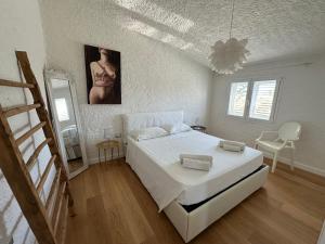 奥尔比亚Boutique Art Villa Maria的白色卧室配有床和镜子