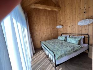 SaraiķiViesuli Village Villa的木墙客房的一张床位