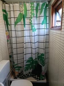 皮滕Vakantiehuisje Veluwe bij Speuldersbos的浴室设有布满植物的浴帘