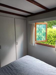 皮滕Vakantiehuisje Veluwe bij Speuldersbos的一间卧室设有一张床和一个窗口