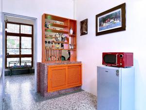 安平区朗香洋房 法式老洋房 台南民宿684編號的厨房配有冰箱和红色微波炉