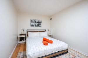 多伦多Modern 2BR Apt - Close to Trinity Bellwoods Park的卧室配有白色床和2个橙色枕头