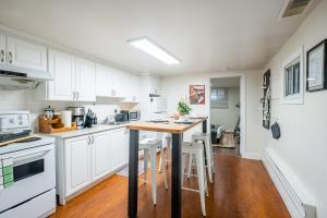 多伦多Modern 2BR Apt - Close to Trinity Bellwoods Park的厨房配有白色橱柜和木桌