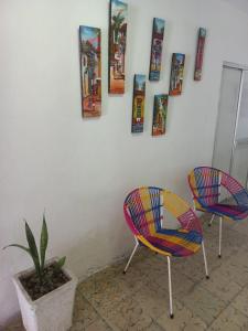 卡塔赫纳posada barrios mar的两把椅子和墙上的植物,上面有图片