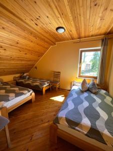 坎达瓦卡克里酒店的一间带两张床的卧室,位于木天花板的房间