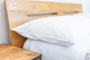 阿尔盖罗MaBi的一张带白色枕头的床,旁边是木桌