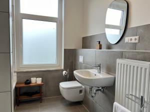 希尔德斯海姆FLATLIGHT - Stylish apartment - Kitchen - Parking - Netflix的一间带水槽、卫生间和镜子的浴室