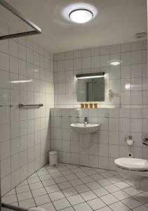 比克堡巴克贝格步奥豪斯酒店的白色瓷砖浴室设有水槽和卫生间