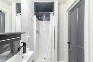汉密尔顿Apartment in the James South Neighborhood的带淋浴和盥洗盆的白色浴室