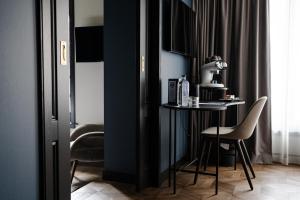 乌得勒支The Nox Hotel的一间黑色客房,配有小桌子和椅子