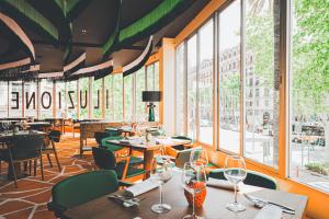 巴塞罗那Hesperia Barcelona Presidente的餐厅设有桌椅和窗户。