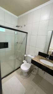 阿拉卡茹Pousada Santa Fé的浴室配有卫生间、淋浴和盥洗盆。