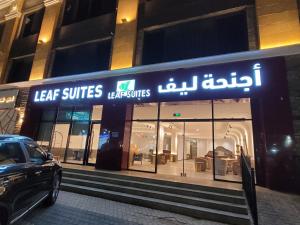 赖斯Leaf Suites أجنحة ليف的大楼前的商店,前面有停车位