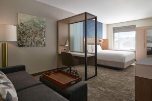埃文SpringHill Suites by Marriott Avon Vail Valley的酒店客房设有沙发、床和镜子