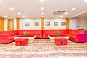乌代浦FabExpress Mewar Shine的客厅配有红色的沙发和桌子