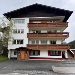 沃瑟姆阿尔伯格Hillside One - Ski-In Ski-Out Apartments am Arlberg的一座白色的大建筑,设有木屋顶