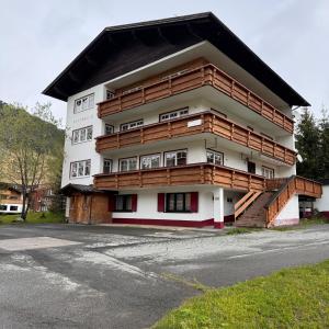 沃瑟姆阿尔伯格Hillside One - Ski-In Ski-Out Apartments am Arlberg的旁边设有木制阳台的建筑