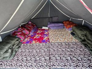 KedārnāthKedar Tent House的帐篷内的一张床位,配有毯子和枕头
