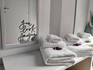 博洛尼亚Bologna Travel Suite的镜子前的架子上堆着的毛巾