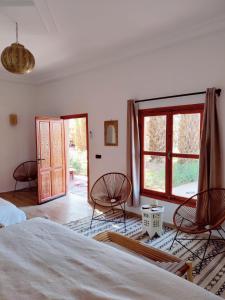 扎古拉Zagora Oasis Lodge的一间卧室配有两把椅子和大窗户