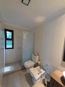 查克拉斯德科里亚Alto Chacras Cottage的白色的浴室设有卫生间和水槽。