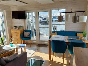 艾恩松Houseboat Hecht in Egernsund at the Marina Minde的客厅配有桌子和蓝色椅子