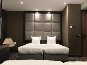 阿姆斯特丹乐维尔酒店的一间带两张床和大床头的卧室