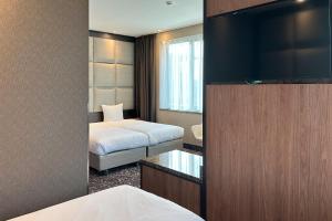阿姆斯特丹乐维尔酒店的酒店客房,配有床和电视