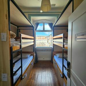 里斯本Rossio Hostel的客房设有三张双层床和一扇窗户。