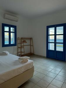 利普西岛Lipsi Blue Hotel的一间卧室设有床、两个窗户和梯子