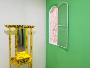 库尼亚hospedagem Manaká proximo ao Centro vista incrível的绿色的墙,带有镜子和黄色的梯子