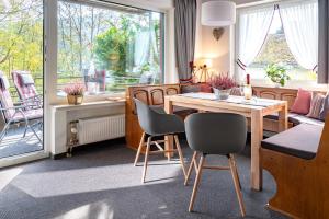 维林根Bergglück Willingen的客厅设有餐桌和椅子