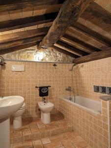 Nibbiano穆利诺伦提诺度假屋的浴室配有卫生间、盥洗盆和浴缸。