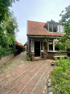 卑尔根Tiny House De Oude Berg的前面有砖砌庭院的房子