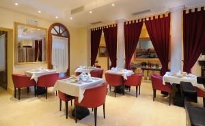 威尼斯埃杜尔普林西皮酒店的一间带两张桌子和红色椅子的餐厅