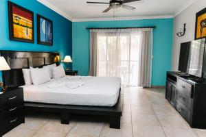 蓬塔卡纳Hotel Brisa的一间蓝色卧室,配有一张床和电视