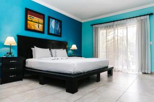 蓬塔卡纳Hotel Brisa的一间卧室配有一张带蓝色墙壁的大床